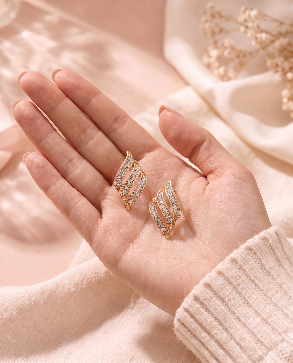 Dione Earrings held in the palm