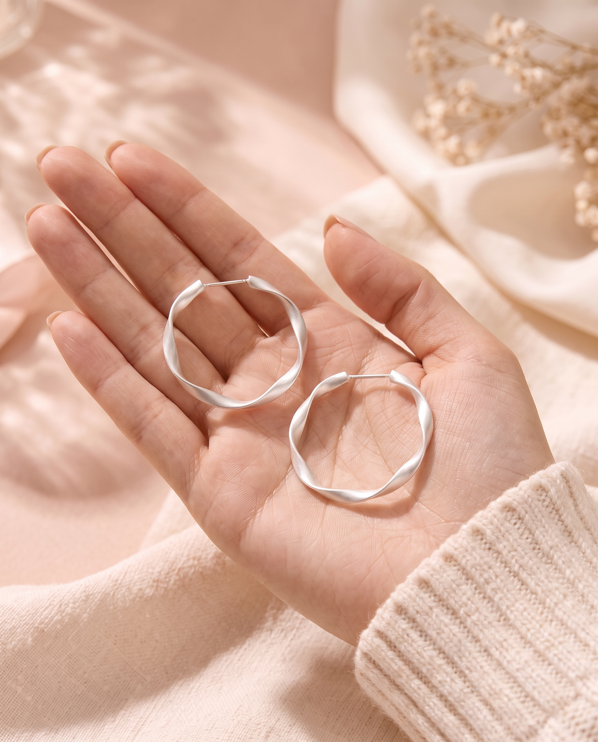 Cupid Earrings held in the palm